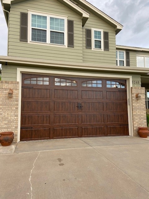 Woodgrain carriage-house door with arched windows