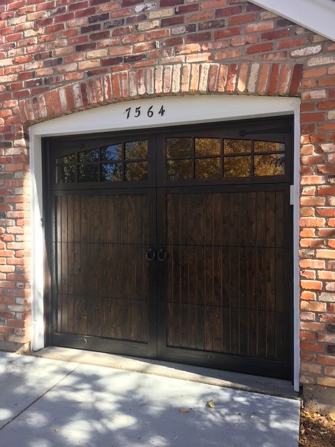 Dark-stained wood carriage door with arched windows